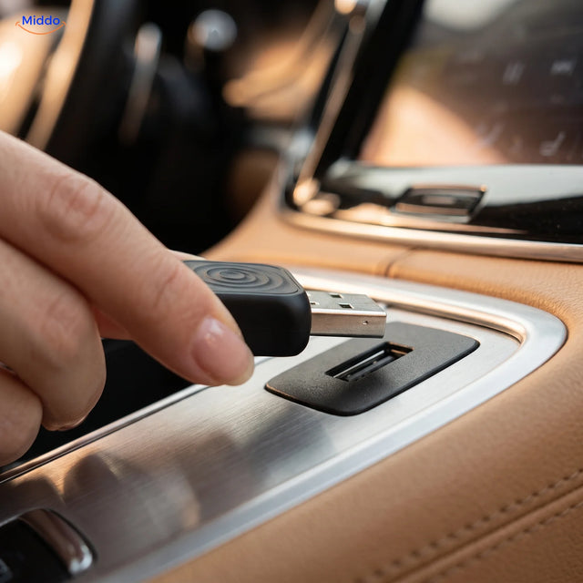 Une main branche l’adaptateur CarLink Pro dans le port USB de la console centrale