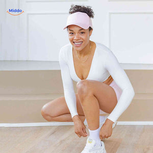 casquette ponytail rose portée avec des boucles courtes, tenue de sport, sourire naturel