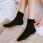 chaussettes en velours d'hiver noires portées aux pieds, finition douce