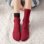 chaussettes en velours d'hiver rouges portées aux pieds, coloris festif