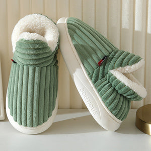 chaussons verts en fluffy fleece avec doublure blanche posés devant un rideau beige