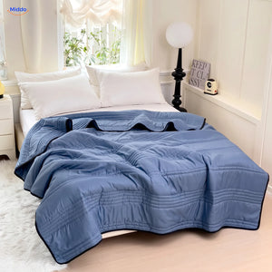 Couverture rafraîchissante Coolwave coloris bleu foncé sur un lit fait
