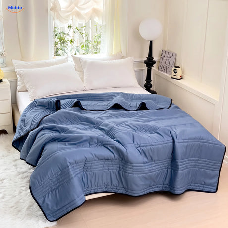 Couverture rafraîchissante Coolwave coloris bleu foncé sur un lit fait
