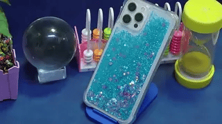 coque téléphone sable glitter bleu et rose disposée en flatlay