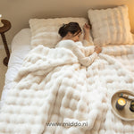 personne endormie sous une couverture toison toscane dans une chambre aux tons beiges