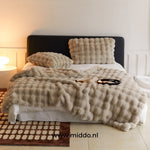 couverture d'hiver toscane beige sur un lit dans une chambre chaleureuse et cosy