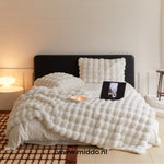 couverture d'hiver toscane blanche sur un lit, tablette et coussin en arrière-plan