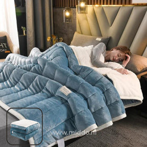 couverture en laine peluche bleue drapée sur un lit, personne endormie au chaud