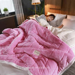 couverture en laine peluche rose pâle moelleuse sur un lit, personne endormie