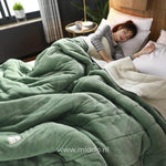 couverture en laine peluche verte sur un lit, ambiance cosy avec personne endormie
