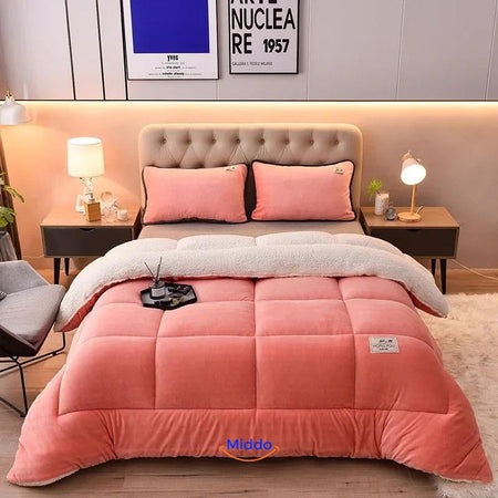 couverture pondérée en laine veloutée coloris orange rosé drapée sur un lit