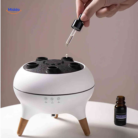 remplissage du diffuseur flamora avec une pipette et un flacon d'huile essentielle