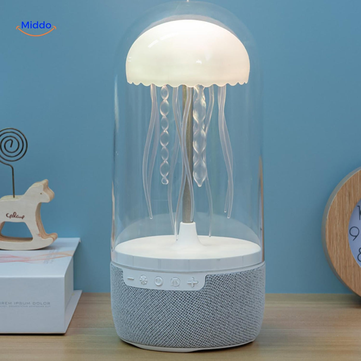 enceinte bluetooth jellyglow allumee sur un bureau avec lumiere chaude et douce en interieur