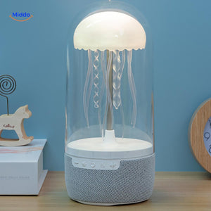 enceinte bluetooth jellyglow allumee sur un bureau avec lumiere chaude et douce en interieur