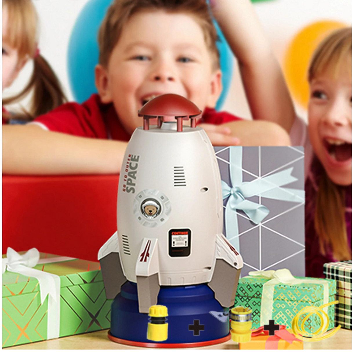 enfants qui jouent avec la fusée arroseur près d'une table de cadeaux en été
