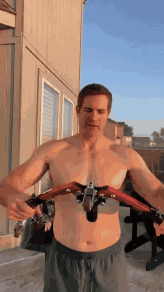 homme utilisant l'appareil d'entraînement pour les bras lors d'un workout en extérieur