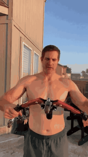 homme utilisant l'appareil d'entraînement pour les bras lors d'un workout en extérieur