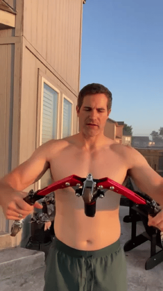 homme utilisant l'appareil d'entraînement pour les bras lors d'un workout en extérieur