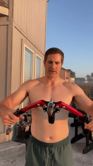 homme utilisant l'appareil d'entraînement pour les bras lors d'un workout en extérieur