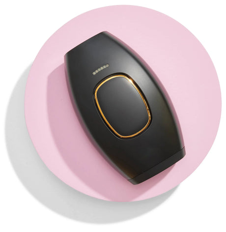 épilateur IPL coloris noir posé sur fond rose pastel