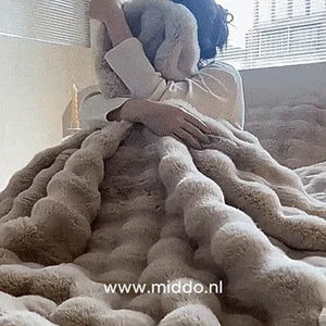 femme lovée dans une couverture toscane fluffy, atmosphère chaleureuse et cocooning