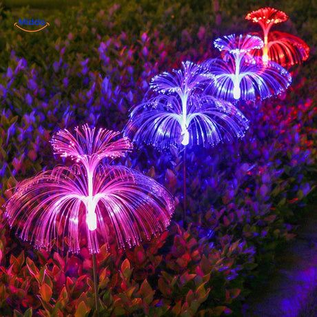 fontaine solaire fiber optic aux couleurs rose, bleu et rouge illuminant le jardin la nuit