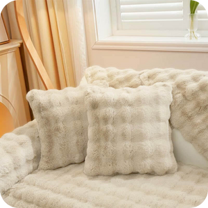 coussins et plaid blancs moelleux sur un canapé clair pour une déco lumineuse et douce
