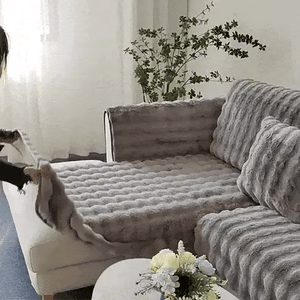 femme installant une housse de canapé grise et moelleuse sur son canapé