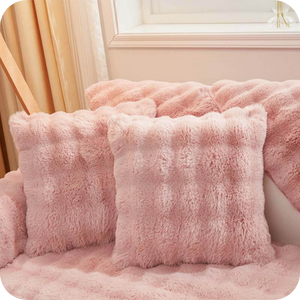 coussins et plaid roses moelleux sur un canapé près d'une fenêtre, ambiance douce et féminine