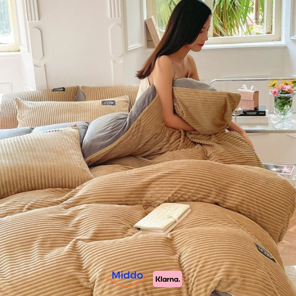 femme assise sur son lit avec housse de couette en polaire beige, en train de lire un livre