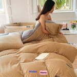 femme assise sur son lit avec housse de couette en polaire beige, en train de lire un livre