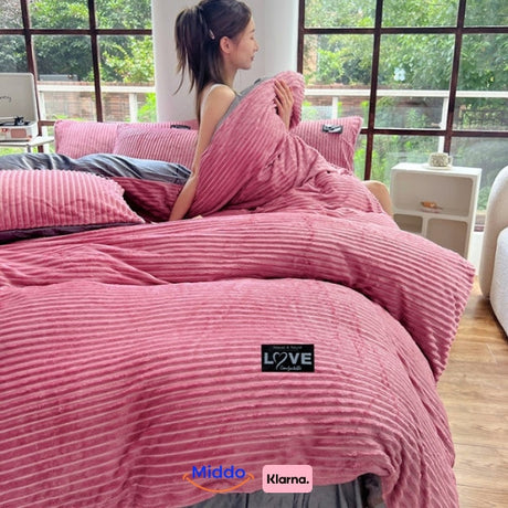 housse de couette en polaire rose sur lit avec une femme, grandes fenêtres lumineuses