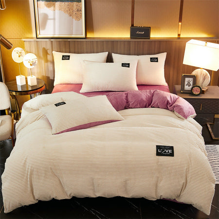housse de couette en velours polaire blanc face rose visible sur un lit, avec oreillers assortis posés dessus