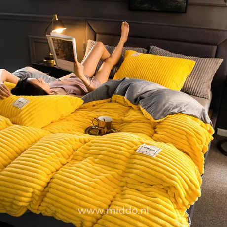 femme allongée sur son lit avec un magazine posé sur la housse de couette en velours polaire jaune