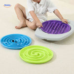 enfant changeant les disques labyrinthe mauves, verts et bleus du jeu d'equilibre balancio