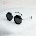 lunettes de soleil rondes avec monture dorée et verres noirs, finition artisanale élégante