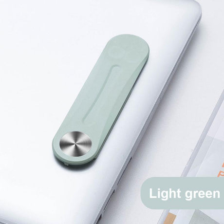 clip magnétique vert replié et fixé sur un ordinateur portable, compact et discret