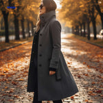 manteau gris à coupe longue entouré de feuilles d'automne, ambiance saisonnière