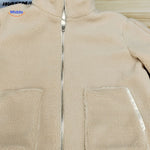 manteau teddy beige sur fond blanc, présentation épurée de la coupe et du coloris