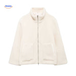 manteau en laine teddy beige photographié en pleine lumière naturelle