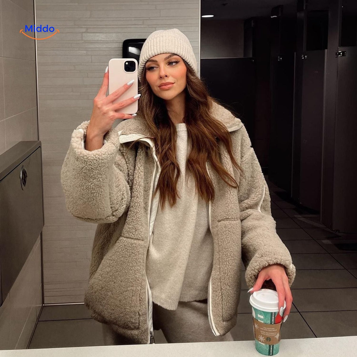 manteau en laine teddy beige porté devant un miroir avec écharpe assortie