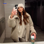 manteau en laine teddy beige porté devant un miroir avec écharpe assortie