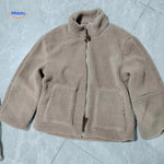 manteau teddy beige posé à plat sur le sol, aperçu du tombé et de la matière