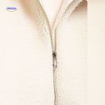 manteau en laine teddy blanc porté dans un ascenseur, look urbain et confortable