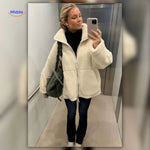 manteau teddy blanc porté en situation dans la rue, look cosy et élégant