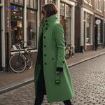manteau long vert porté dans une rue urbaine, silhouette élégante en ville