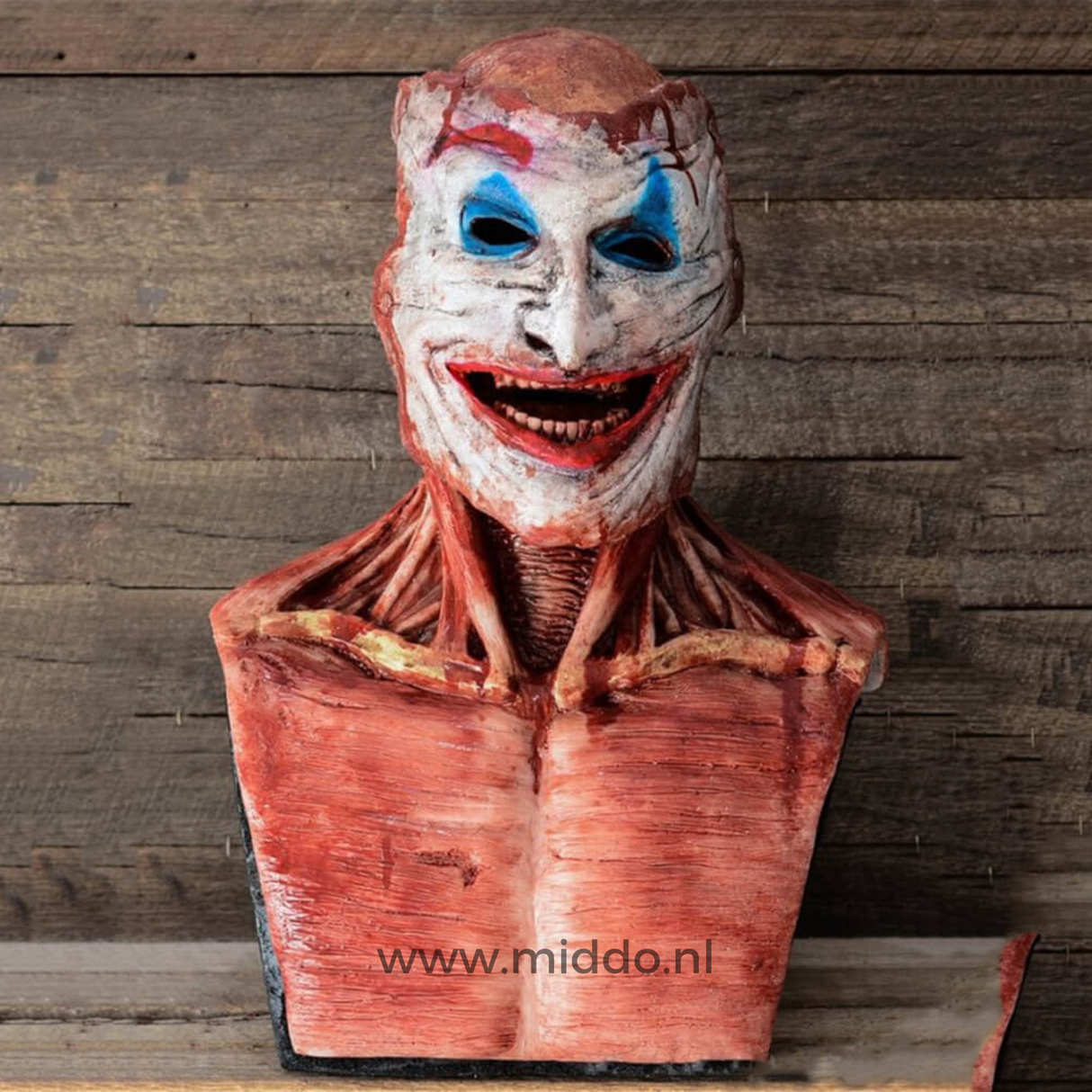 masque peel-off halloween visage de clown terrifiant posé sur fond en bois