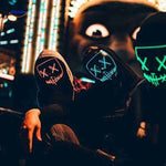 groupe de personnes portant des masques LED de différentes couleurs la nuit pour halloween