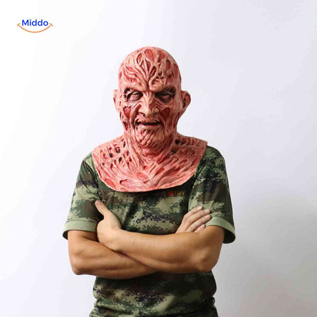 personne portant un masque zombie brûlé en chemise camouflage avec bras croisés