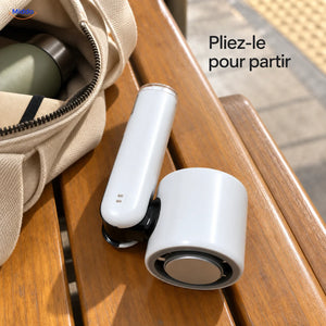Palmora ventilateur à main pliable: modèle blanc plié près d’un sac de voyage.